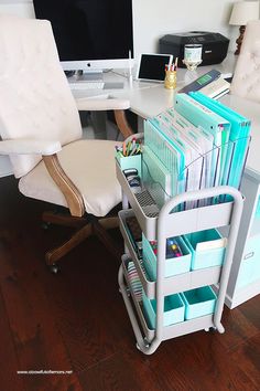 a desk with a chair, computer monitor and many folders on top of it