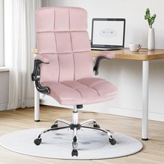 a pink office chair sitting on top of a white rug next to a computer desk