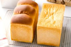 three loaves of bread sitting on top of a cooling rack next to each other