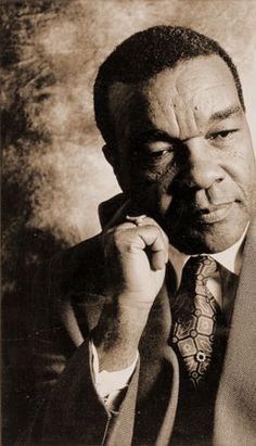 an old photo of a man in a suit and tie holding his hand up to his face