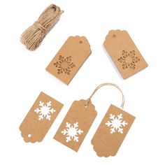 four tags with snowflakes on them next to twine and twine cord