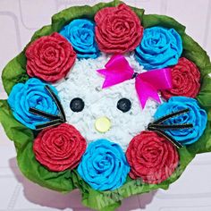 a bouquet of flowers with a kitty face on the center and red, white, and blue roses in the middle