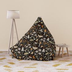 a bean bag chair sitting on top of a rug next to a table and lamp