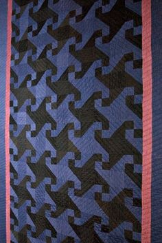 a blue and black quilt with pink trim