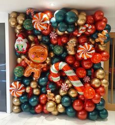 an assortment of christmas decorations and balloons in the shape of a giant gingerbread man