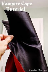 a person is holding up a black and red jacket