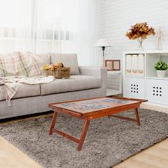 a living room with a couch, coffee table and rug in front of the window