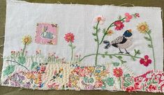 a piece of fabric with flowers and birds on it