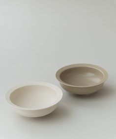 two white bowls sitting next to each other