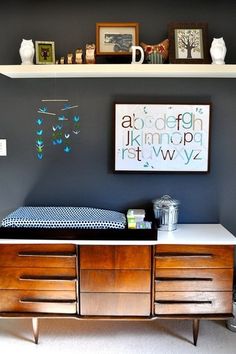 a baby crib is shown in front of two bookshelves with pictures on the wall