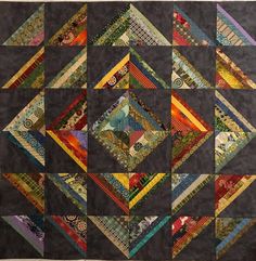 a quilted wall hanging with many different designs on it's sides and the bottom half