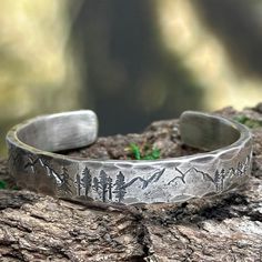 The mountains are a special place. This cuff bracelet is my homage to the mountains -a rustic handmade bracelet that celebrates the beauty of nature and the majesty of the forest with the mountains and trees hand stamped around the rustic sterling silver cuff.  This bracelet is 9.5mm wide and a very solid 3mm thick.  Perfect for the hunter or hiker in your life.  This engraved silver bracelet is hand forged and finished with a hammered finish to give it a rustic look, perfect for men and women a Silver Engraved Bracelet, Black Sharpie, Sterling Silver Cuff Bracelet, Sterling Silver Cuff, Personalized Bracelets, Silver Cuff Bracelet, Silver Cuff, Gifts For Husband, Sterling Silver Bracelets