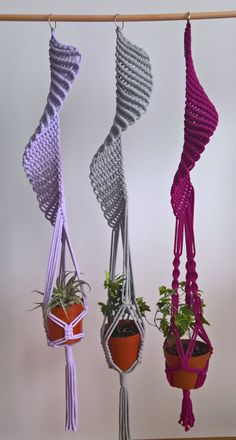 three hanging planters with plants in them