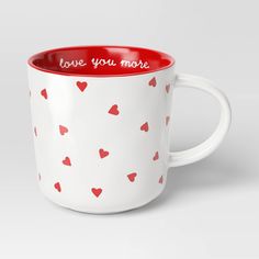 a red and white coffee cup with hearts on it