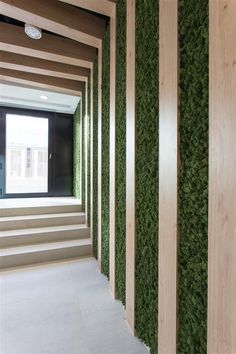 the interior of a building with green plants on the wall and stairs leading up to it