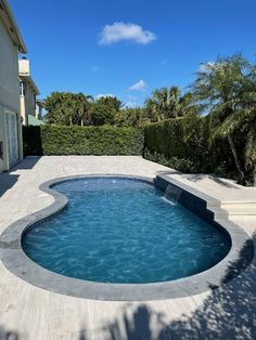 an empty swimming pool with steps leading up to it and palm trees in the background