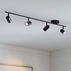 three black track lights are hanging from the ceiling