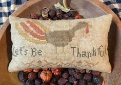 a bowl filled with raisins next to a pillow that says, let's be thanksgiving