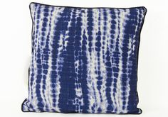 a blue and white tie - dyed pillow on a white background with black piping