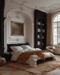 a large bed sitting in the middle of a bedroom next to a book shelf and window