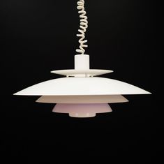 a white light hanging from a black ceiling