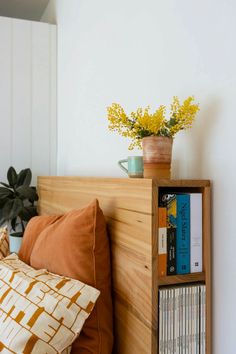 a bed with a wooden headboard and bookshelf next to it on top of a pillow