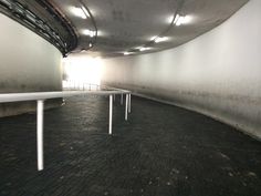 an empty parking garage with white benches and railings