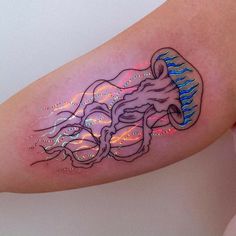 a woman's arm with a jellyfish tattoo on the left side of her body