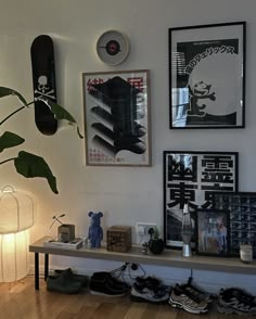 there is a shelf with shoes on it in the corner next to a lamp and pictures