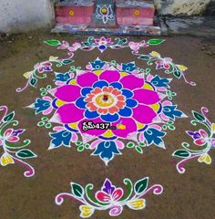 a colorful flower design on the ground in front of a building