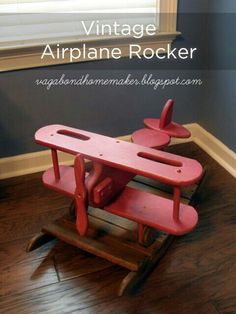 an old wooden airplane rockerer is sitting on the floor in front of a window