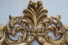 an ornate gold headboard is shown against a white wall