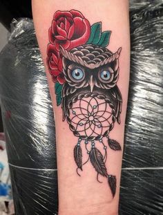 an owl with roses on it's head is sitting next to a rose tattoo