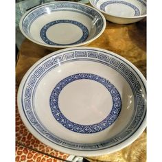 three blue and white bowls sitting on top of a table