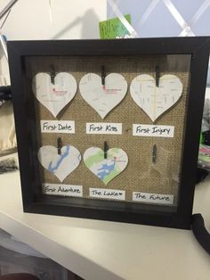 there are many heart shaped pictures on the wall in this frame, and each one is labeled with their own name