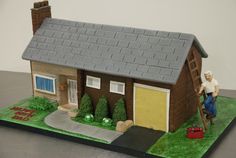 a cake that is shaped like a house with a man climbing up the side of it