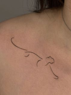 the back of a woman's shoulder with a cat tattoo on her left side