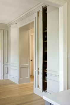 an empty room with white walls and wooden floors is seen in this image from the doorway