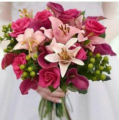 a bride holding a bouquet of pink flowers