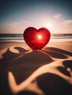 a heart shaped object sitting on top of a sandy beach