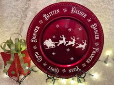 a red glass plate with santa's sleigh and reindeers on it