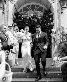 black and white photo of bride and groom leaving the church after their wedding ceremony with confetti thrown in the air