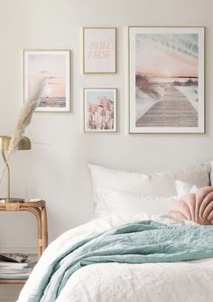 a bedroom with white walls and pictures on the wall