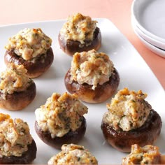 a white plate topped with mini stuffed mushrooms