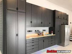 a kitchen with gray cabinets and stainless steel refrigerator freezer combo next to stairs that lead up to the second floor