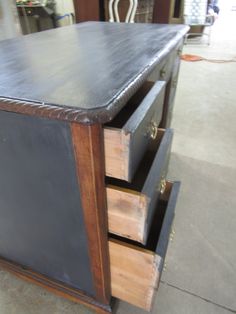 a wooden table with two drawers on it and a chair in the backround