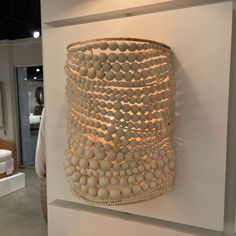 a large white vase sitting on top of a table next to a wall mounted light