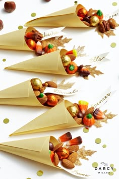 three cones filled with candy and nuts on top of a table