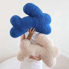 a woman is holding two stuffed animals on her head