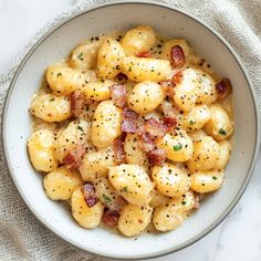 a white bowl filled with macaroni and cheese on top of a table cloth